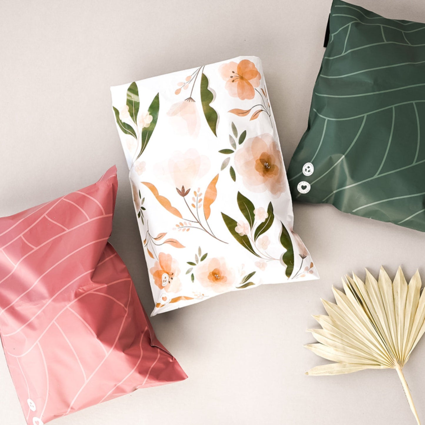 Three Camelia Bloom Biodegradable Mailer bags with flowers and a leaf, featuring a matte effect finish.