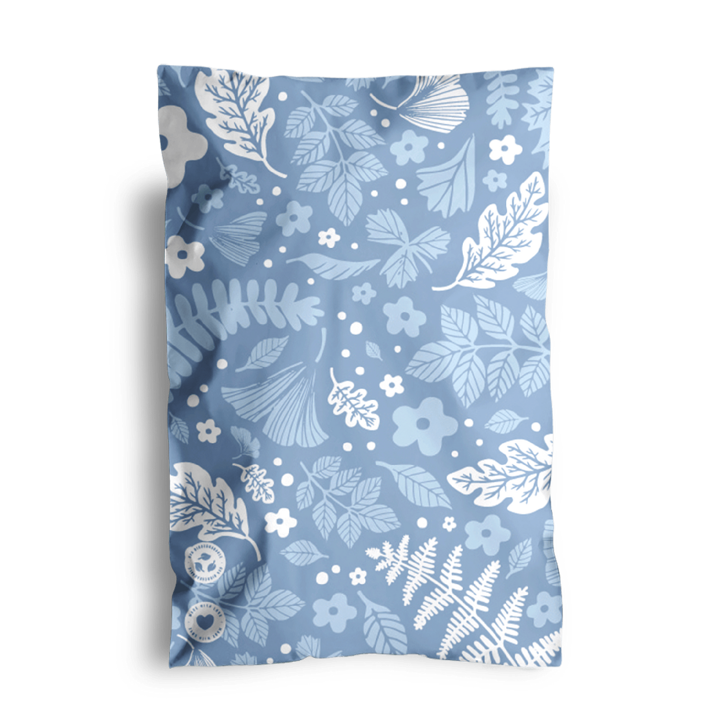 A decorative pillow with a blue floral pattern and two visible buttons, placed against a black background in Sapphire Evergreen Biodegradable Mailers 6" x 9" from impack.co.