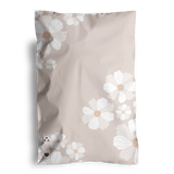 A beige pillowcase featuring white and light brown floral designs, softly echoing the Cosmos print of the impack.co biodegradable mailers.