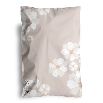 A beige pillowcase featuring white and light brown floral designs, softly echoing the Cosmos print of the impack.co biodegradable mailers.