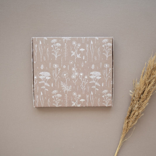 An impack.co ABC Box Wildflower 7" x 8" - Large with a wildflower print on it and a stalk of grass.
