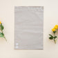 A grey Sandstone Biodegradable Mailer 10" x 13" with flowers and a yellow flower, made from recyclable materials by impack.co.