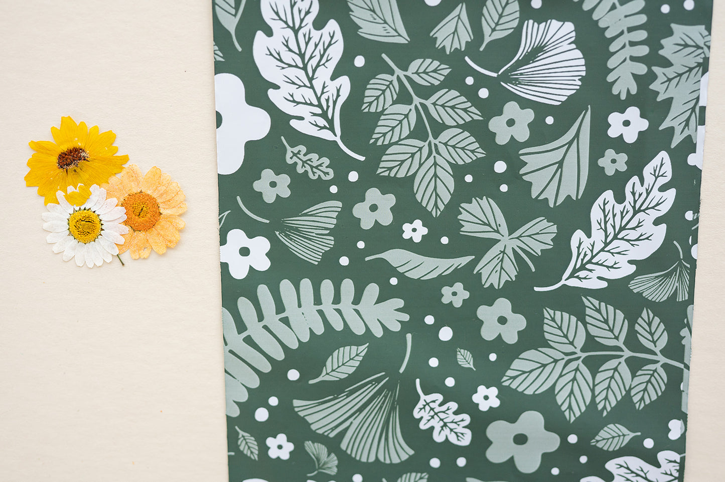 A green and white fabric with flowers and leaves on it, suitable for Emerald Evergreen Biodegradable Mailers 10" x 13" from impack.co.
