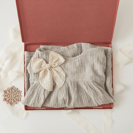 A grey dress with a bow in an impack.co ABC Box Cedar Leaf 9.8" x 13.3" - Extra Large, perfect for shipping needs.