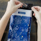 A person is holding a Midnight Indigo Mailers 6" x 9" recyclable bag from impack.co.