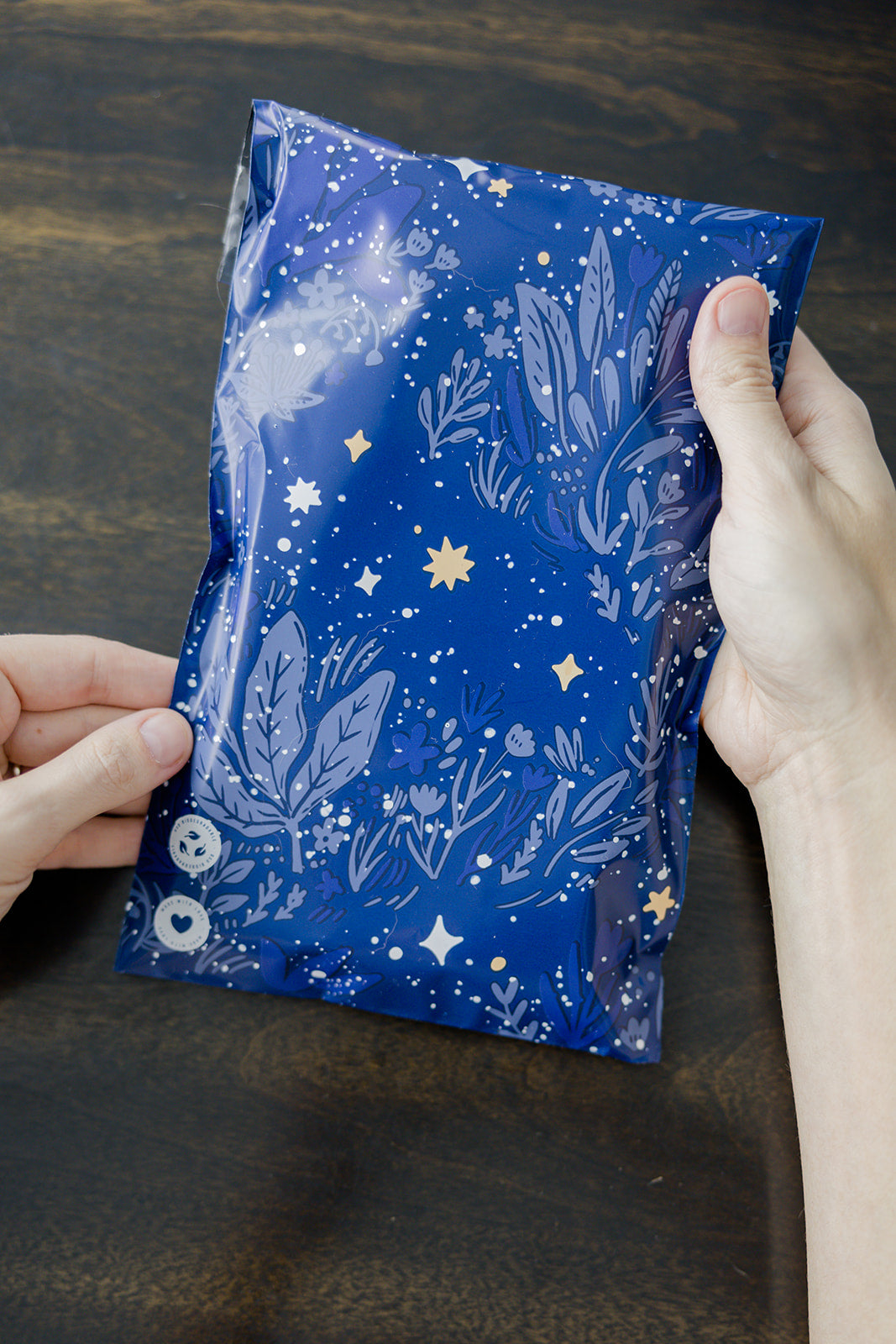 A person holding a Midnight Indigo Mailers 6" x 9" bag with stars on it from impack.co.