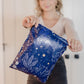 A woman holding up a Midnight Indigo Mailers 10" x 13" bag from impack.co.