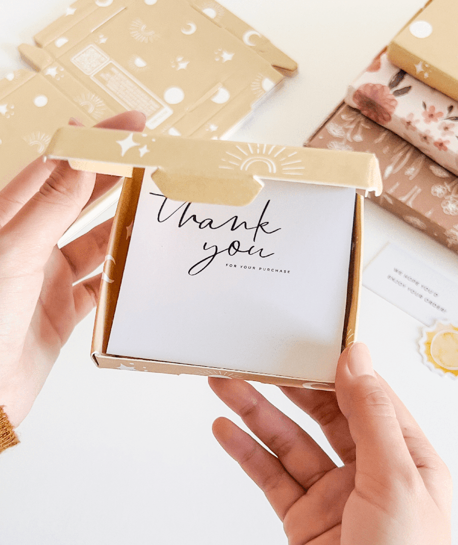 A person holding a thank you card with an impack.co celestial print in front of an ABC Box Celestial 4" x 4" - Small, considering aesthetics and shipping costs.