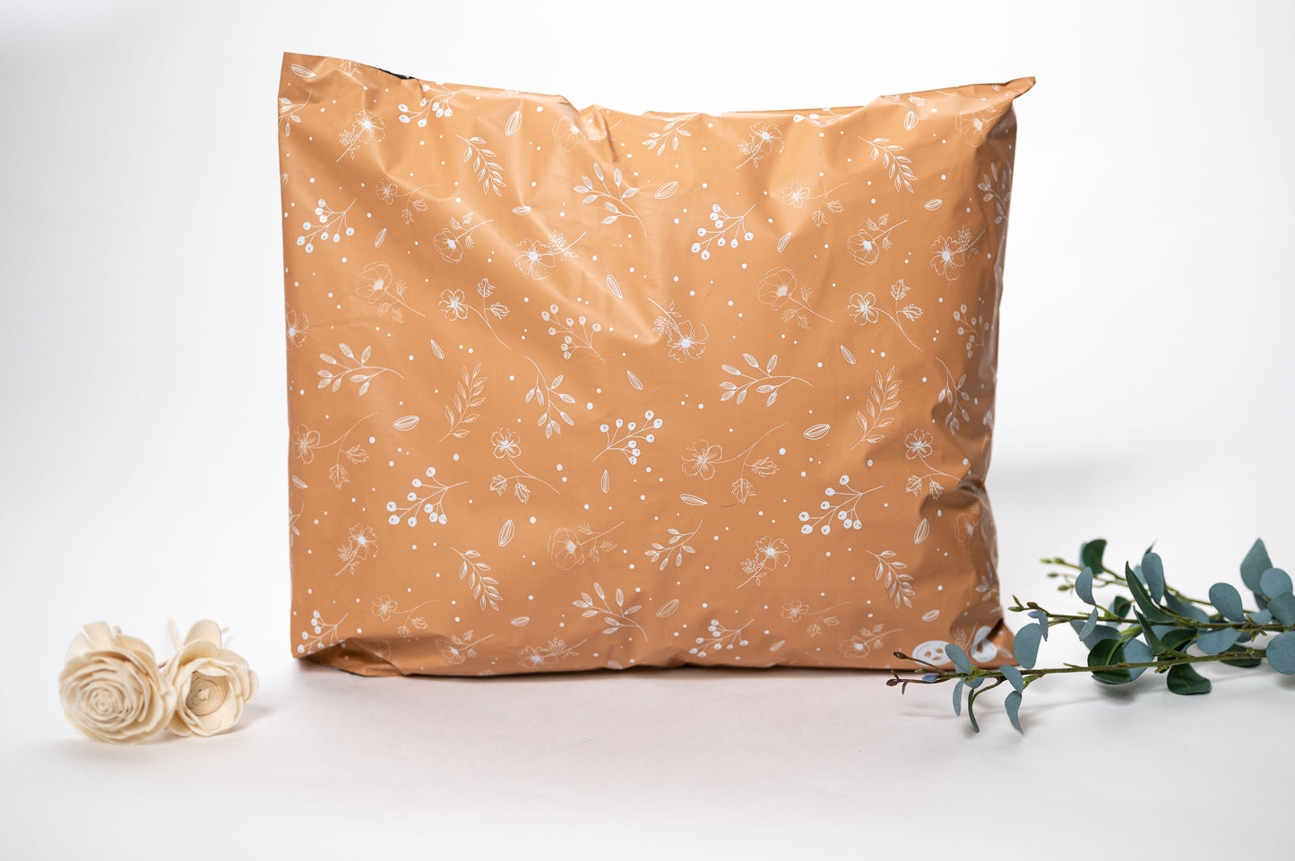 A Floral 2D Chestnut Biodegradable Mailer 12" x 15.5" with a flower next to it, made from a recyclable material, from impack.co.