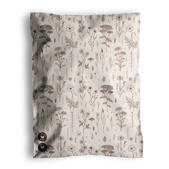 The Wildflower Biodegradable Mailers from impack.co feature a crumpled fabric design adorned with a pattern of brown flowers and plants on a white background, exuding an eco-friendly charm. Tiny buttons in the bottom left corner subtly echo the intricate details commonly seen on biodegradable mailers.