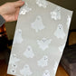 A person is holding up a sheet of paper with eco-friendly impack.co Halloween Ghost Ivory Mailers 10" x 13" printed with ghosts on it.