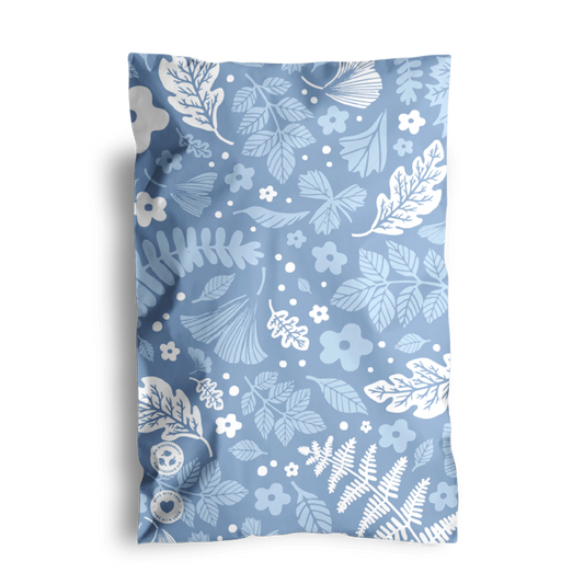 A decorative pillow with a blue floral pattern and two visible buttons, placed against a black background in Sapphire Evergreen Biodegradable Mailers 6" x 9" from impack.co.