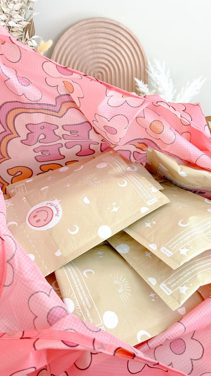An eco-conscious Celestial Padded Paper Mailers 6" x 9" bag filled with pink and white paper from impack.co.
