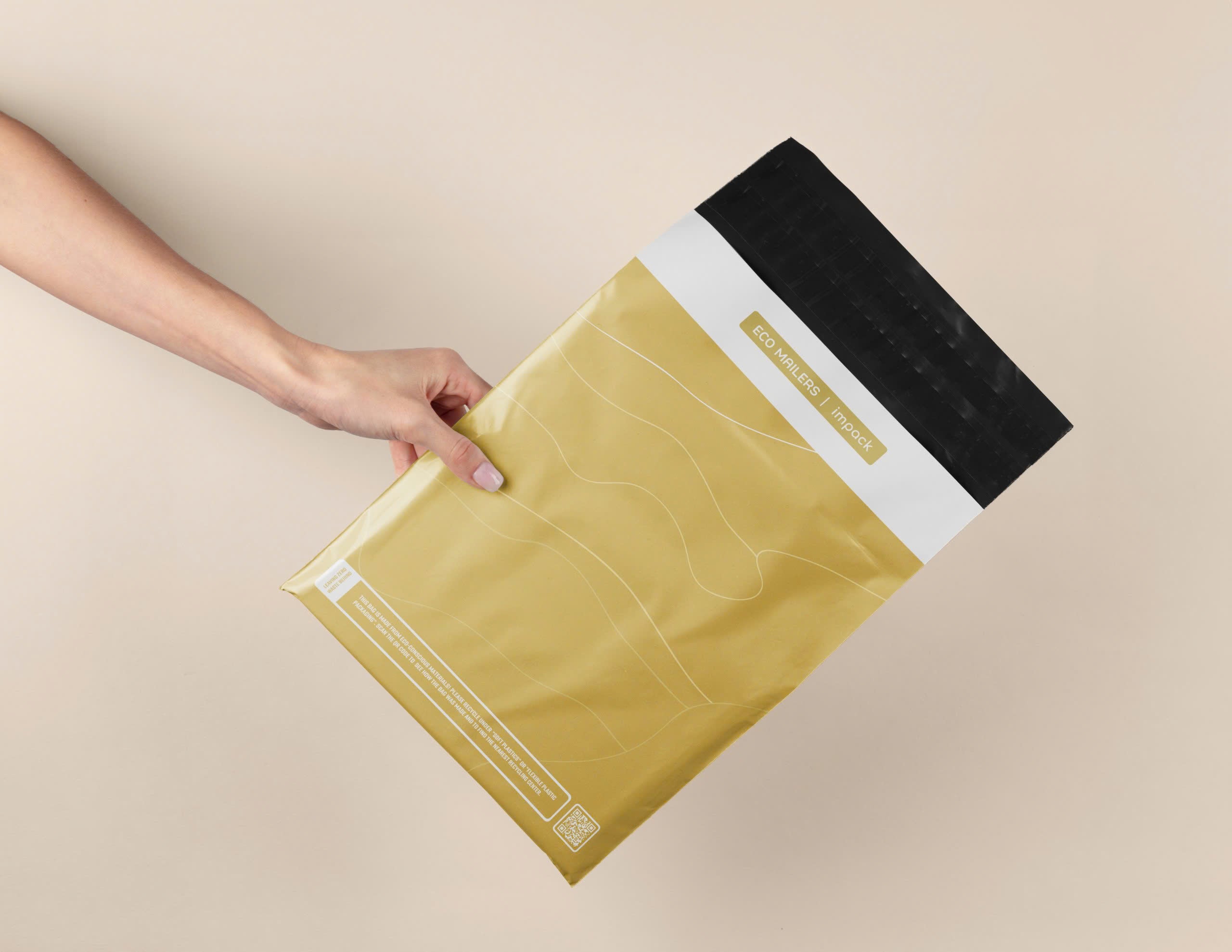 A hand holds a yellow and black mailing envelope labeled "Tidal Amber Mailers 10'' x 13''" by impack.co, featuring abstract white line designs, offering an eco-friendly biodegradable mailer solution.