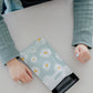 A woman is holding a bag with Daisy White Biodegradable Mailers 6" x 9" from impack.co on it.