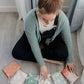 A woman is sitting on the floor with several impack.co biodegradable mailer 6" x 9" bags in front of her.