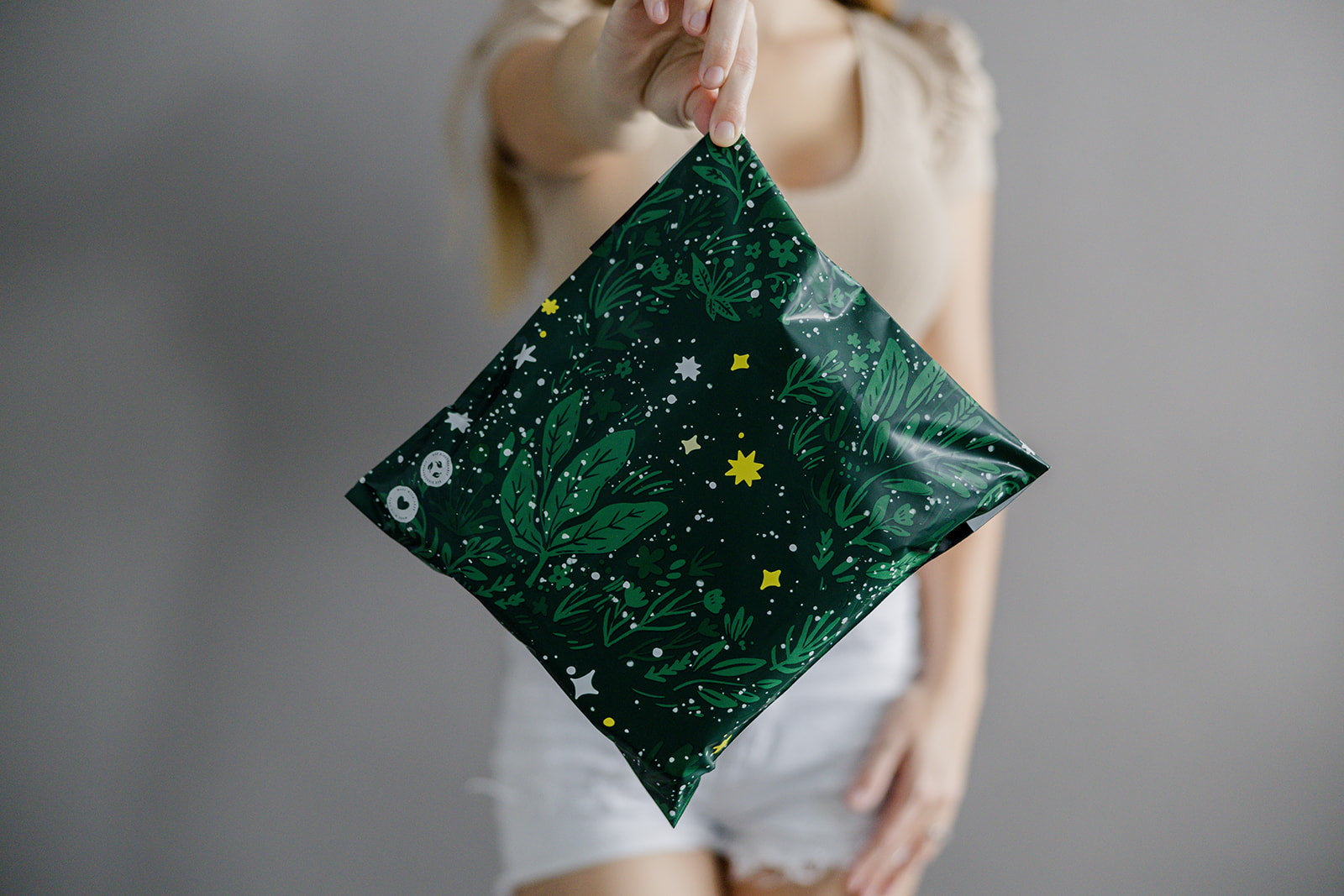 A woman is holding up a Midnight Lush Mailers 14.5" x 19" bag with stars on it from impack.co.