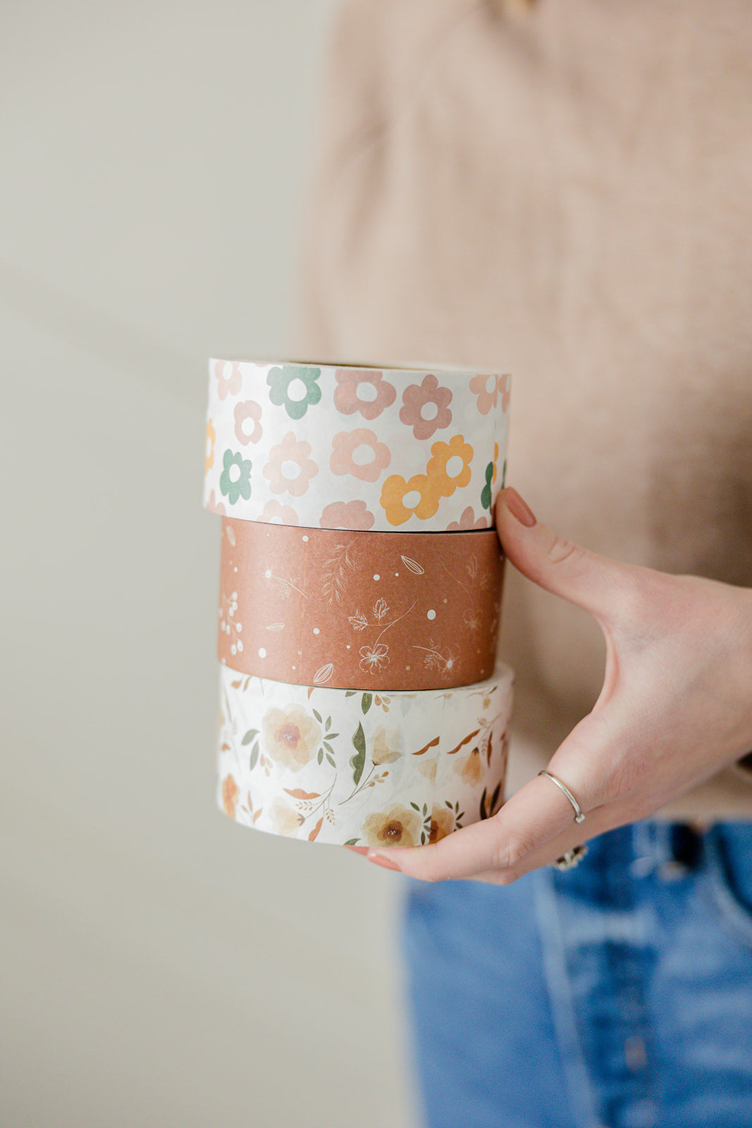 A woman holding up three rolls of Packing Tape - Floral Rosy Brown from impack.co.