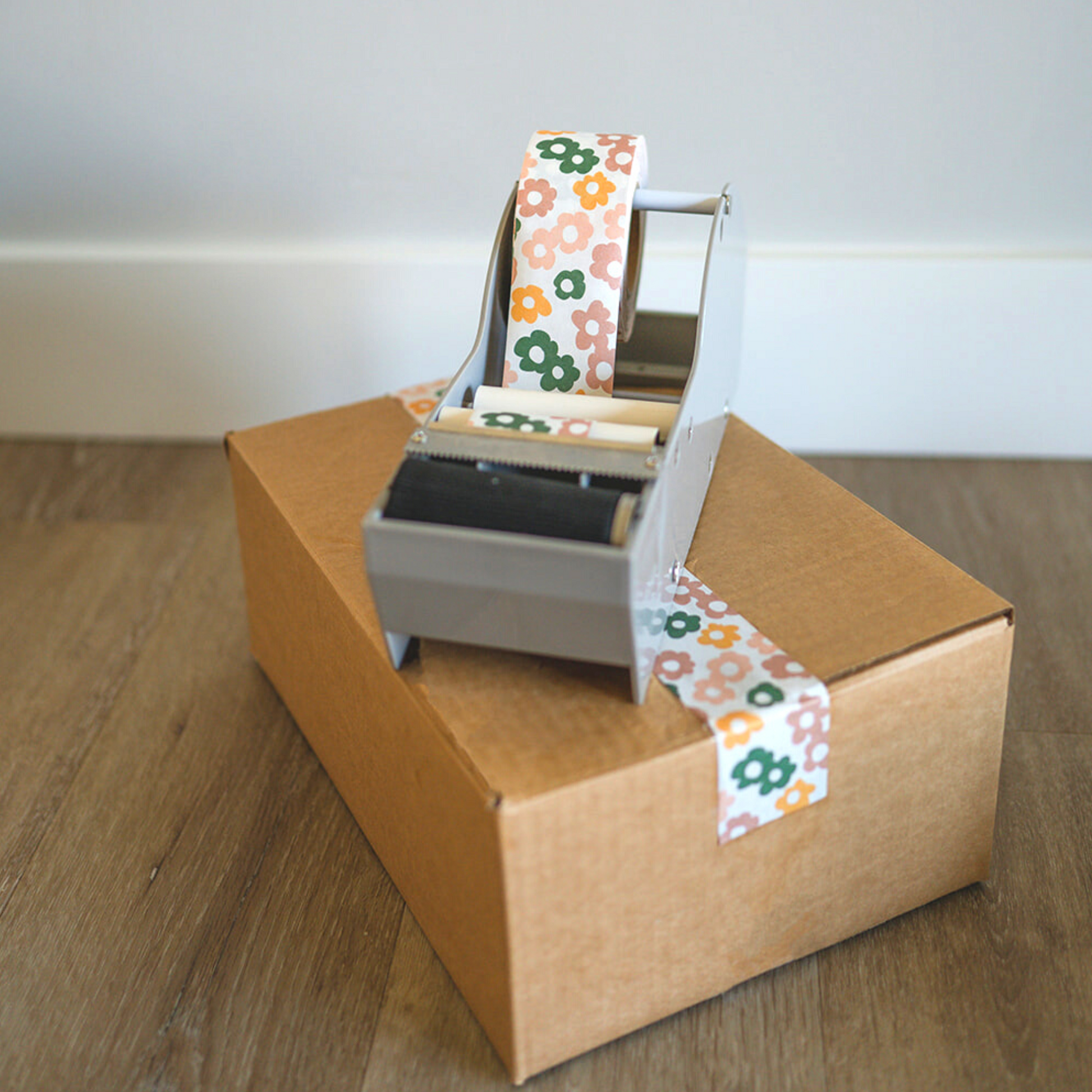 A Daisy Multi tape dispenser sits on top of a cardboard box - impack.co.
