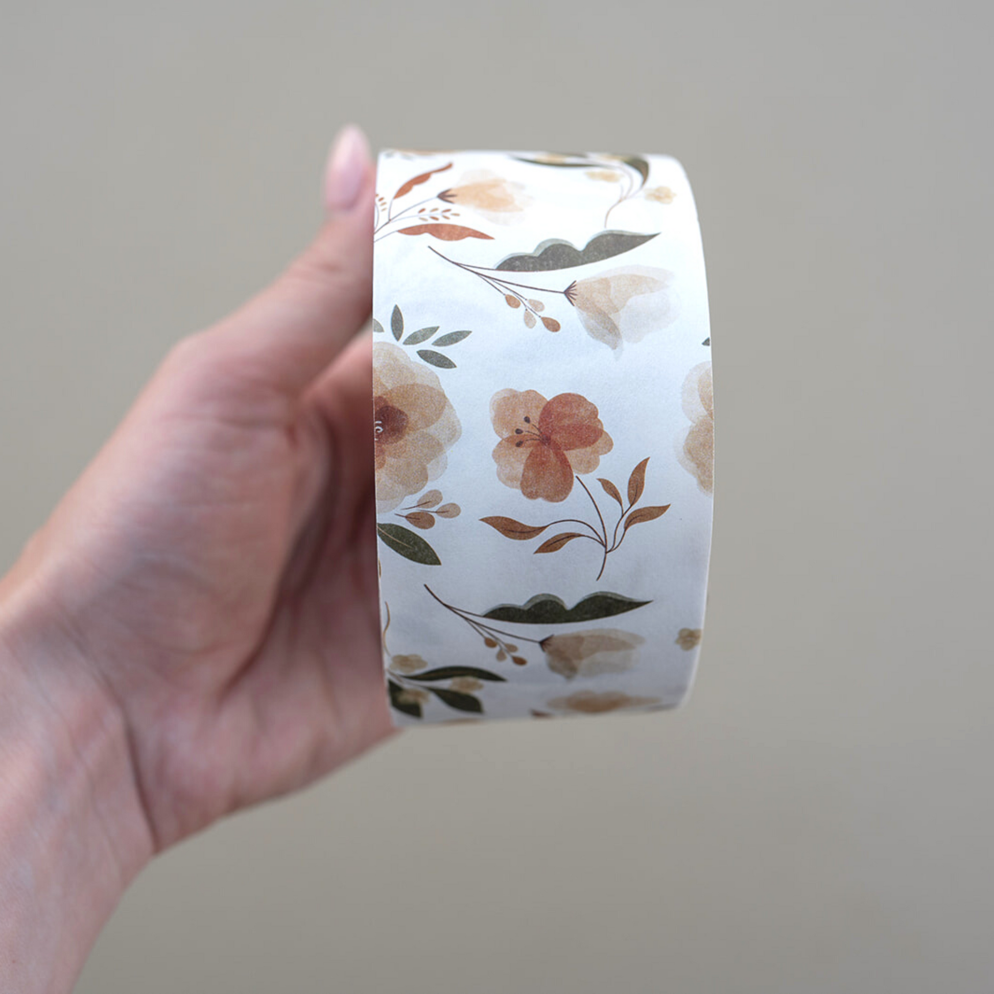 A hand holding a roll of Packing Tape - Camelia Bloom by impack.co.